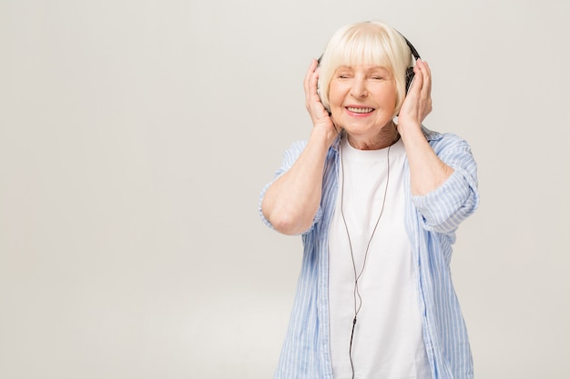Premium Photo | Elderly woman with headphones listening to music on a