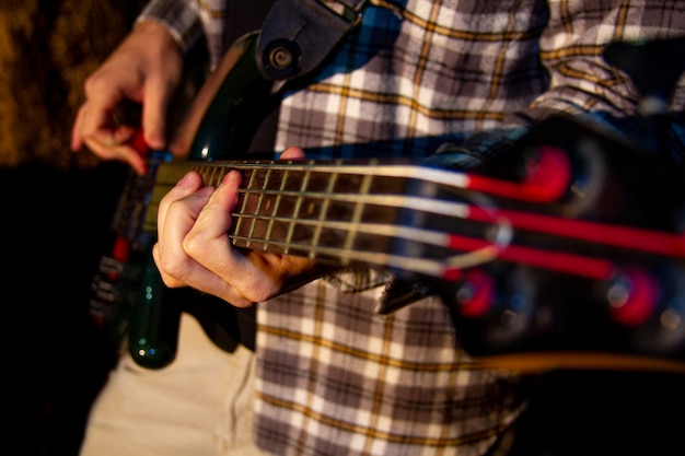 Premium Photo Electric Bass Guitar Player Closeup Photo With Soft Selective Focus