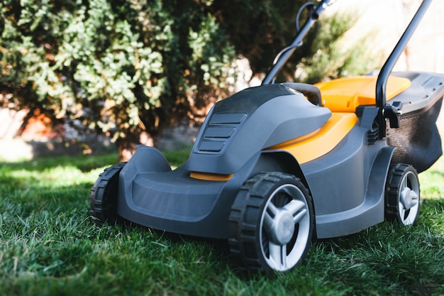 Electric lawn mower on a lawn at the garden. Premium Photo