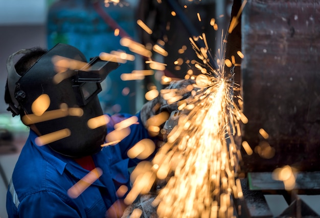 Electric wheel grinding on steel pipe in factory Premium Photo