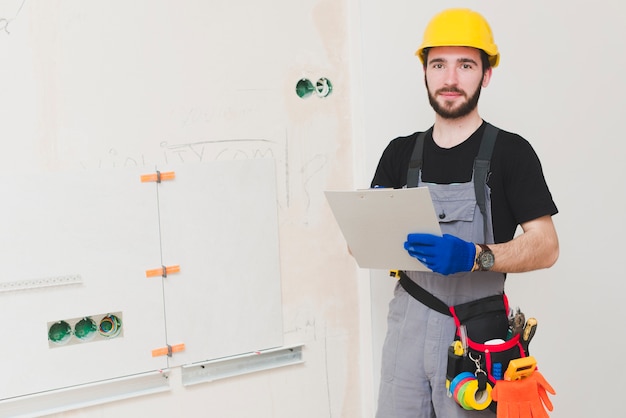 Electrician standing with paper folder Photo | Free Download