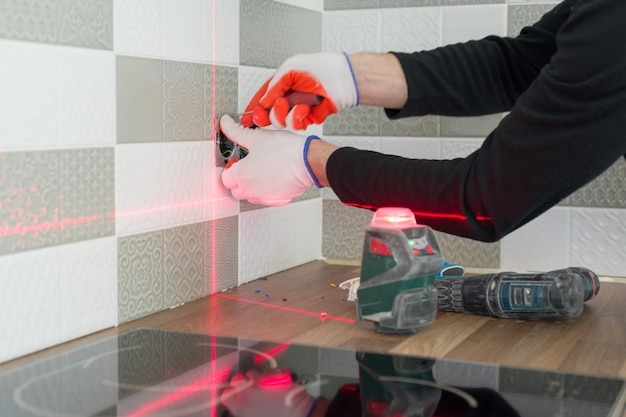 Premium Photo | Electrician Using Infrared Laser Level To Install ...