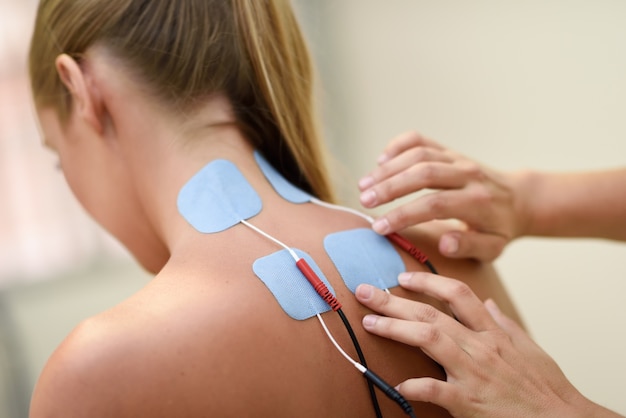 Electro stimulation in physical therapy to a young woman Free Photo