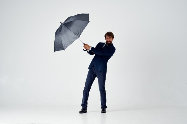 Premium Photo | Elegant gentleman with a dark umbrella on a light