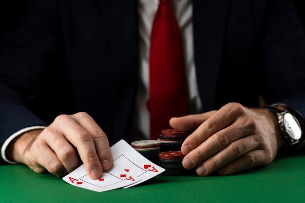 Premium Photo Elegant Man At Green Playing Table With Gambling Chips And Cards Playing Poker And Blackjack In Casino