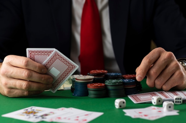 Premium Photo Elegant Man At Green Playing Table With Gambling Chips And Cards Playing Poker And Blackjack In Casino