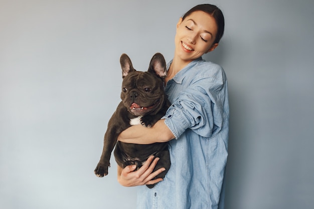 Elegant woman in a blue shirt with black bulldog Free Photo