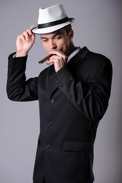 Premium Photo | Elegant young handsome man in a business suit with a cigar.