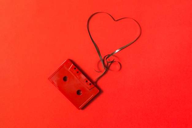 Free Photo Elevated View Of Audio Cassette With Tangled Heart Shape Tape On Red Background