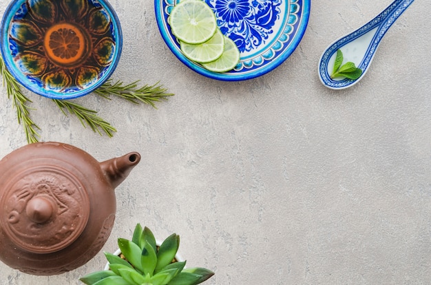 An elevated view of ginger lemon tea with ingredients on concrete backdrop Free Photo