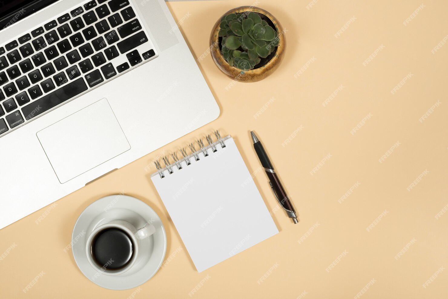 Free Photo | Elevated view of laptop; coffee cup; pen; and spiral ...