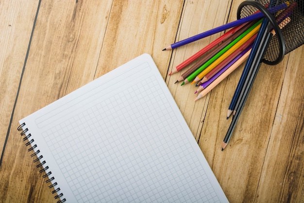 Free Photo | Elevated view of notepad and colorful pencils on wooden