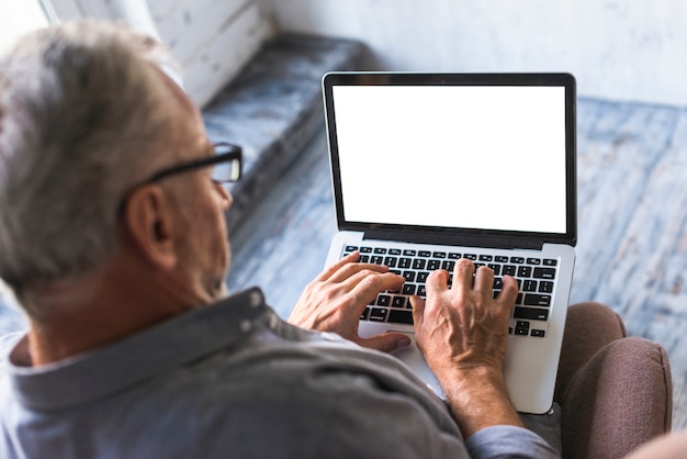 Elevated view of man using laptop with white blank screen Free Photo Elevated view of man using laptop with white blank screen Free Photo