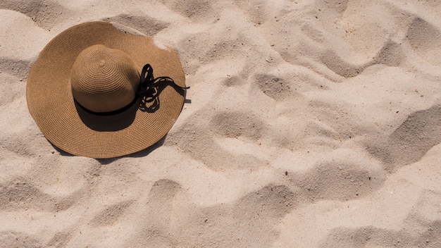 An elevated view of sunhat on beach sand | Free Photo