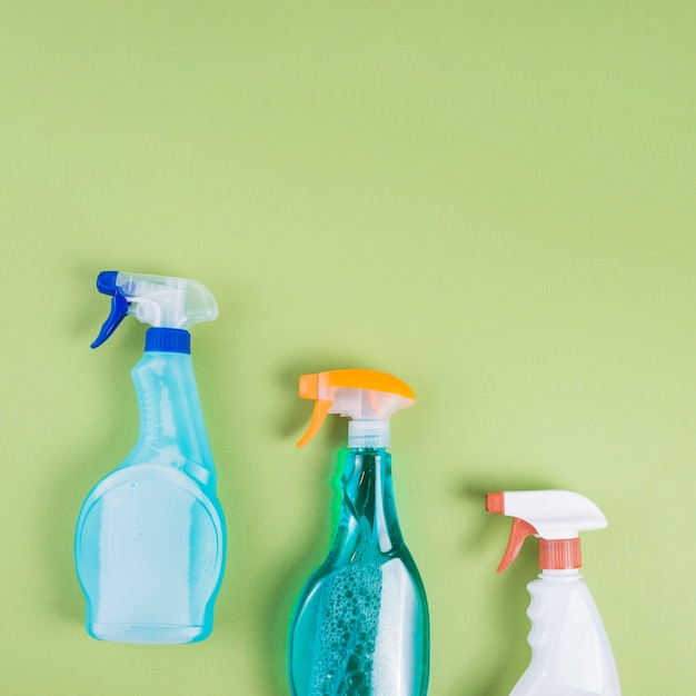 Free Photo | Elevated view of three spray bottles on green background