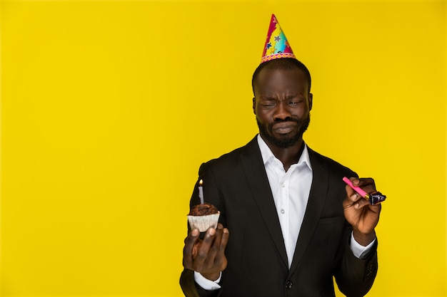 誕生日ケーキとホイッスルを持って恥ずかしいかわいい黒人 無料の写真