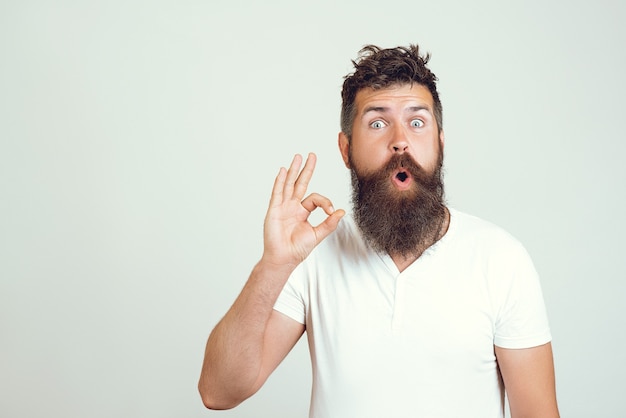 Premium Photo | Emotional surprised bearded male shows ok sign with ...