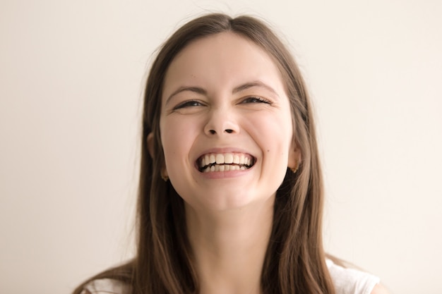 Emotive headshot portrait  of laughing  young woman Free Photo 