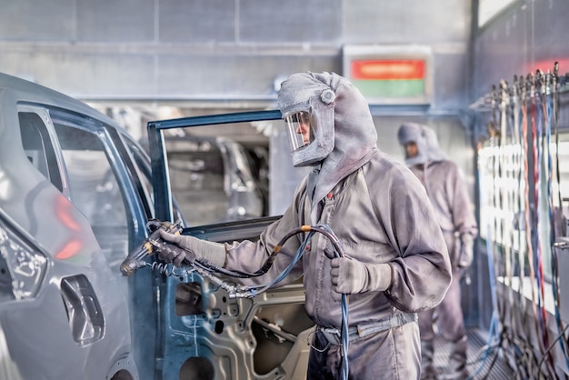 Premium Photo | Employee of the car body painting shop performs painting.