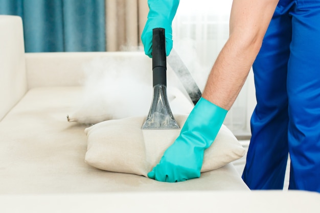 An employee of a cleaning company provides a chemical and steam cleaning service for the sofa. | Premium Photo