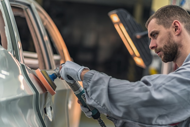 Premium Photo | Employee polishing a freshly painted car