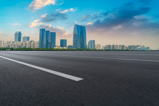 Premium Photo | Empty asphalt road along modern commercial buildings in ...