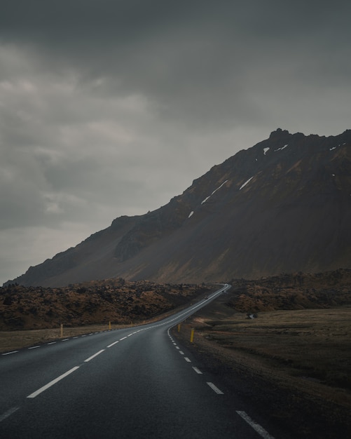 Free Photo | Empty curvy road next to a beautiful rocky mountain under ...