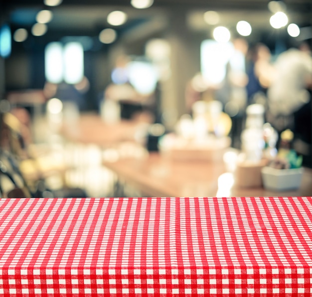 Empty Table With Red Check Table Cloth Over Blurred Cafe Background