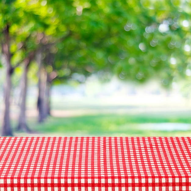 Empty Table With Red And White Tablecloth Over Blurred Park