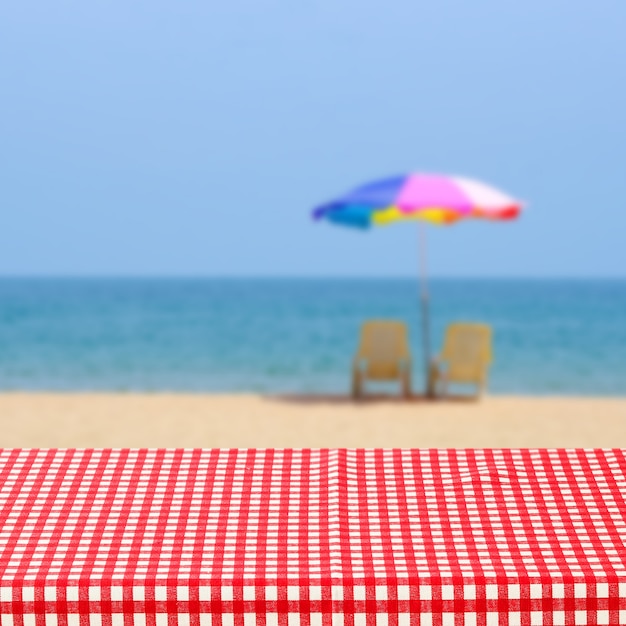 Empty Table With Red And White Tablecloth Over Blurred Sea Outdoor Nature Background, For Product Di