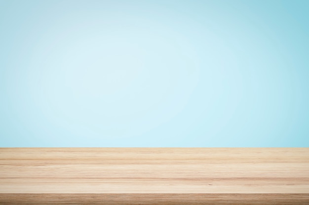 現在の製品の水色の壁紙の背景の上の空の木製デッキテーブル プレミアム写真
