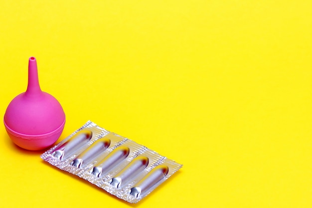 Download Premium Photo Enema In Medicine Medical Suppositories In A Silver Blister Pack And A Pink Rubber Medical Enema On A Yellow Background Packaging Of Contraceptives Vaginal Rectal Candles PSD Mockup Templates