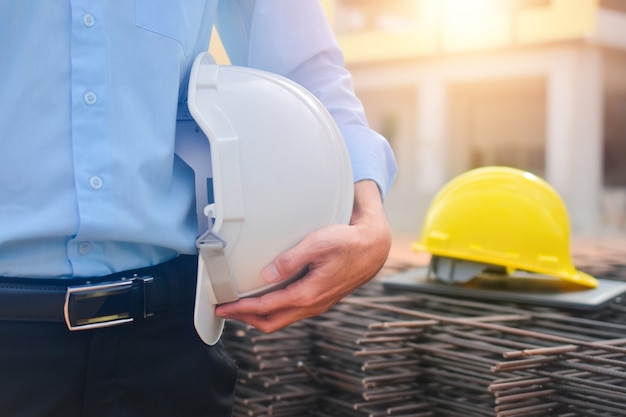 Premium Photo | Engineer holding hardhat standing at construction site ...