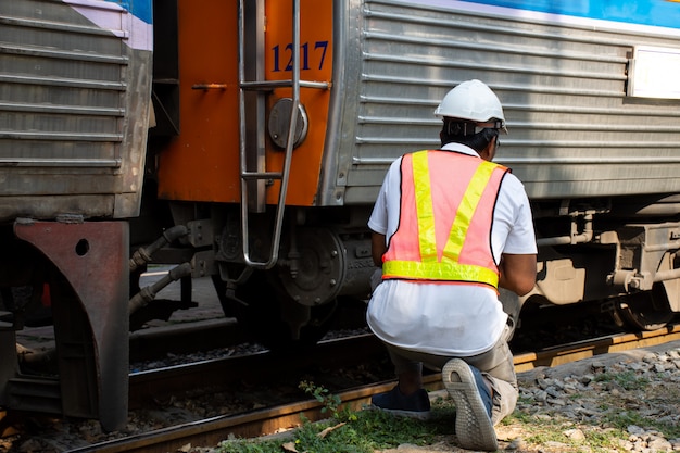 Engineer wearing safety helmet with checking train