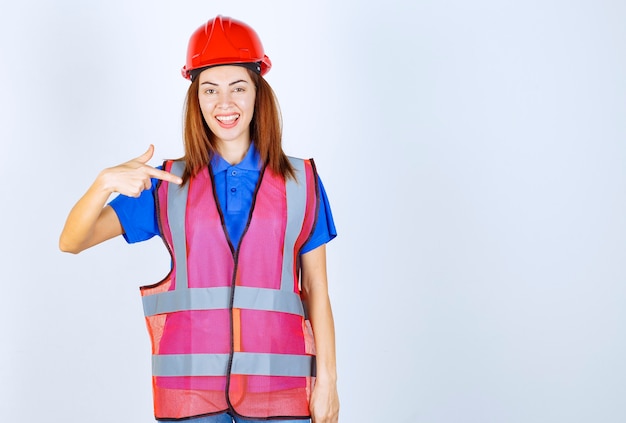 Free Photo | Engineer woman in uniform and red helmet introducing herself.