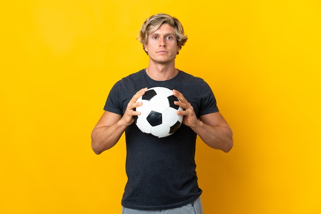 サッカーボールと黄色のイギリス人男性 プレミアム写真
