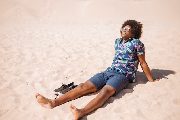 砂浜のビーチで裸足でリラックスできる民族の男性 無料の写真