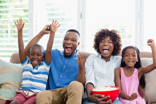 Premium Photo | Excited family and kids watching television while ...