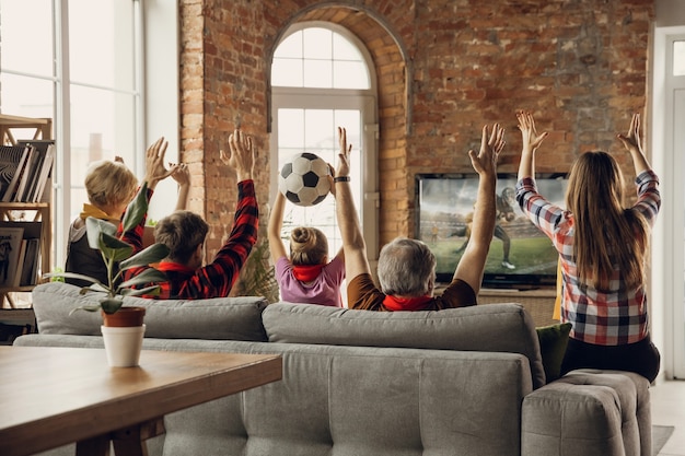 Excited, happy big family team watch sport match together on the couch at home Free Photo