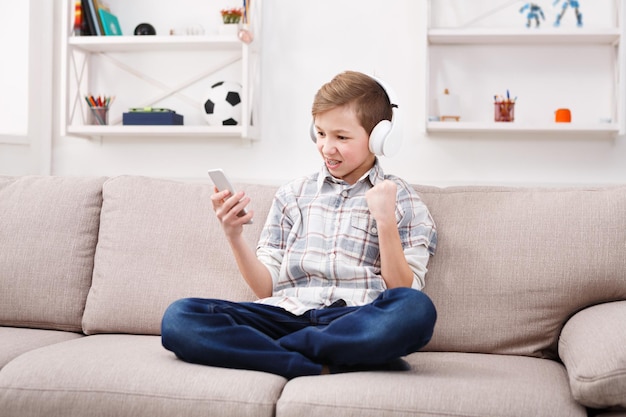 Premium Photo | Excited teenage boy with braces playing football game ...