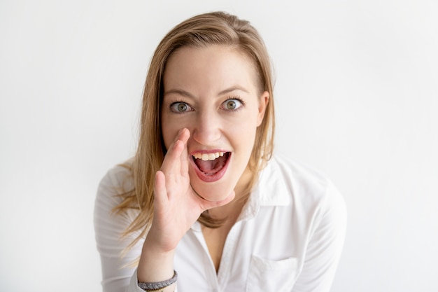 Excited woman holding hand near mouth and shouting loud Photo | Free ...