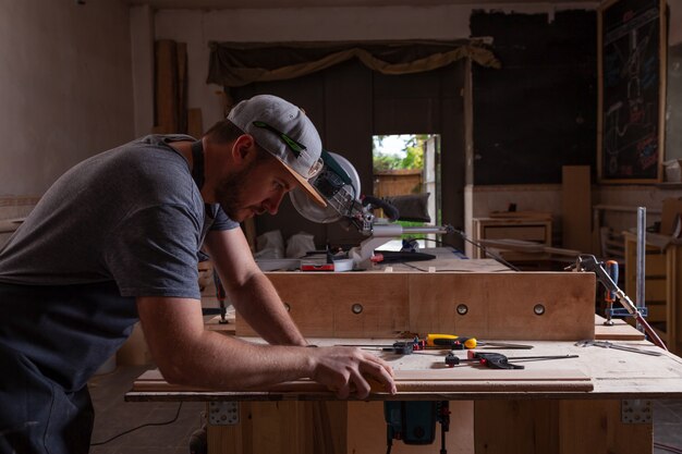 Premium Photo | Experienced carpenter in work clothes working with wood ...