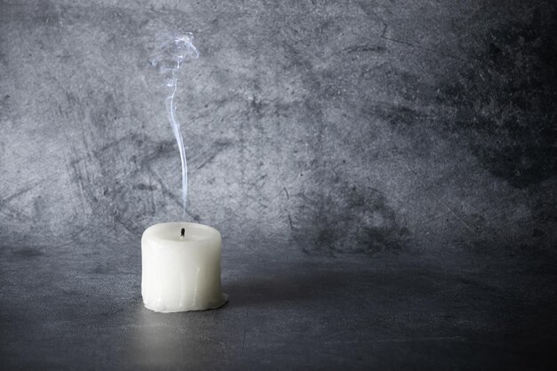 Premium Photo | Extinct candle with plume of smoke on gray background