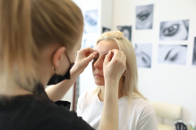 Premium Photo  The eyebrow shaper works with the client, makes him 