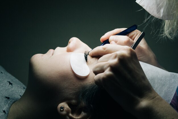 Eyelash extensions. close-up of artificial eyelashes with tweezers. Premium Photo