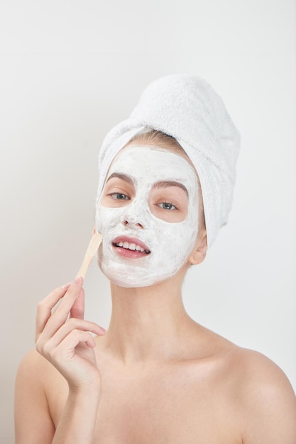 Premium Photo | Facials. a girl with a towel on his head and a mask on ...