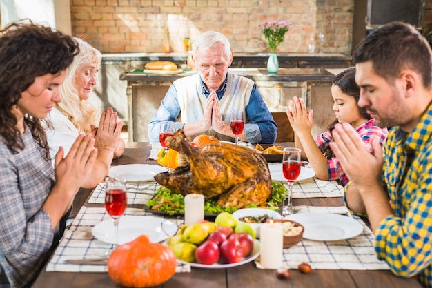 Family at table praying before meals Photo | Free Download