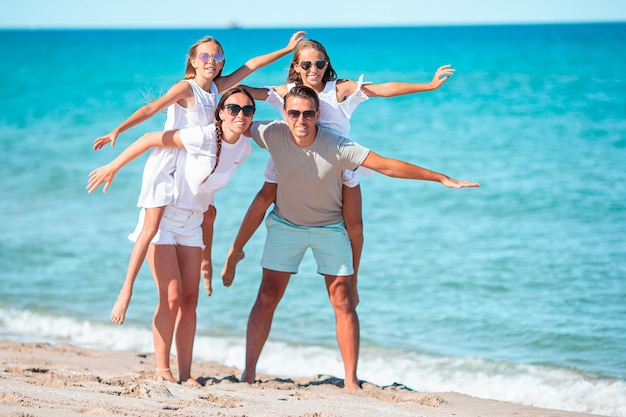 Premium Photo | Family of four having fun together on the beach