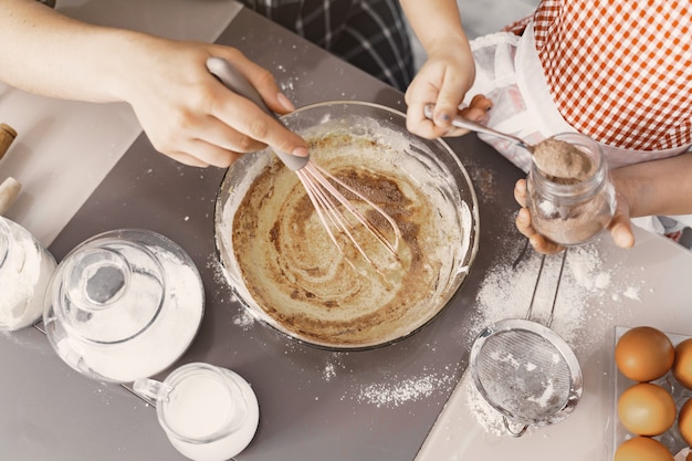 Family in a kitchen cook the dough for cookies Free Photo