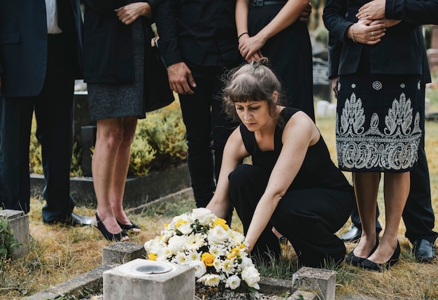 Premium Photo | Family laying flowers on the grave